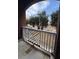 View of outdoor patio with decorative railing, brick siding and view of lush trees and blue sky at 1965 Nocturne Dr # 1103, Alpharetta, GA 30009