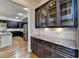 Butlers pantry featuring granite countertops, dark cabinetry and backsplash at 4360 Autry Way, Alpharetta, GA 30022