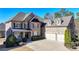 Elegant brick home featuring a three-car garage and meticulous landscaping at 4360 Autry Way, Alpharetta, GA 30022