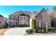 Charming brick home with stone accents, manicured landscaping, and a concrete driveway at 4360 Autry Way, Alpharetta, GA 30022