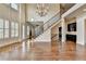 Expansive living room featuring hardwood floors, staircase, fireplace, and modern chandelier at 4360 Autry Way, Alpharetta, GA 30022