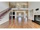 Expansive living room featuring hardwood floors, fireplace with built-ins, second story balcony, and modern chandelier at 4360 Autry Way, Alpharetta, GA 30022