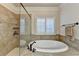 Large soaking tub with tile surround and shuttered window in the Primary bathroom at 4360 Autry Way, Alpharetta, GA 30022