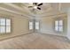 Spacious main bedroom with a tray ceiling, ceiling fan, and large shuttered windows at 4360 Autry Way, Alpharetta, GA 30022