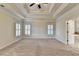 View of main bedroom leading to the en suite bath, with tray ceiling, ceiling fan and shuttered windows at 4360 Autry Way, Alpharetta, GA 30022