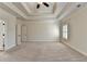 Large main bedroom with tray ceiling, neutral carpet, and access to the en suite bathroom at 4360 Autry Way, Alpharetta, GA 30022