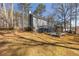 A home's backyard featuring a multilevel deck surrounded by mature trees and landscaped grounds at 710 Melanie Ct, Canton, GA 30115