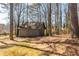 Backyard view of a shed amongst mature trees, offering practical storage space at 710 Melanie Ct, Canton, GA 30115