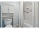 Tiled bathroom with a toilet, shelving storage and shower behind a curtain for privacy at 710 Melanie Ct, Canton, GA 30115