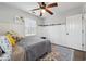 This cozy bedroom features a ceiling fan, carpet, and a large window allowing natural light to illuminate the space at 710 Melanie Ct, Canton, GA 30115