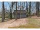 Small gray building nestled among the trees with a yard in the background at 710 Melanie Ct, Canton, GA 30115