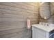 Charming powder room with wood paneling, a round mirror, and a marble countertop vanity at 710 Melanie Ct, Canton, GA 30115