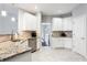 A well-lit kitchen with granite countertops, white cabinets, stainless steel appliances, and tiled floors at 4766 Longcourt Se Dr, Atlanta, GA 30339