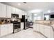Bright kitchen with stainless appliances, white cabinets, granite counters and a view into the dining area at 4766 Longcourt Se Dr, Atlanta, GA 30339