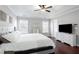 A well-lit main bedroom with hardwood floors, tray ceiling, and a ceiling fan at 4766 Longcourt Se Dr, Atlanta, GA 30339