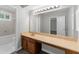 Well-lit bathroom vanity with long countertop, wooden cabinets, large mirror, and adjacent shower and tub at 747 Houston Mill Ne Rd # 1, Atlanta, GA 30329