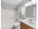 Bathroom featuring white fixtures, wooden vanity, shower, and tub combo with white walls at 747 Houston Mill Ne Rd # 1, Atlanta, GA 30329