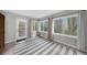 Sunroom with large windows looking out to wooded area with white-framed glass door to back patio at 747 Houston Mill Ne Rd # 1, Atlanta, GA 30329