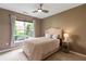 Bright bedroom features a queen-sized bed, a ceiling fan and natural light from the nearby window at 10 Perimeter Summit Ne Blvd # 2112, Atlanta, GA 30319