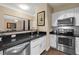 Well-lit kitchen with white cabinets, stainless steel appliances, and dark granite countertops at 10 Perimeter Summit Ne Blvd # 2112, Atlanta, GA 30319