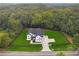 An aerial view of a house with an expansive, newly laid lawn, a black fence, and a mature forest at 3165 Hall Rd, Dacula, GA 30019