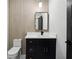 Stylish powder room with black vanity, marble countertop, modern mirror, and contemporary lighting at 3165 Hall Rd, Dacula, GA 30019