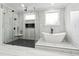 Chic bathroom featuring a modern tub and glass enclosed shower with black and white tiling at 3165 Hall Rd, Dacula, GA 30019