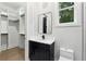 Bathroom features a floating vanity with black fixtures and direct access to a spacious, organized closet at 3165 Hall Rd, Dacula, GA 30019