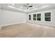 Bright bedroom with tray ceiling, multiple windows offering outdoor views, and modern ceiling fan at 3165 Hall Rd, Dacula, GA 30019