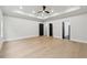 Spacious bedroom with light-colored wood floors, recessed lighting, and multiple doorways, offering versatility at 3165 Hall Rd, Dacula, GA 30019