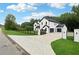 A modern home featuring a long driveway leading to a three-car garage and white and black exterior at 3165 Hall Rd, Dacula, GA 30019