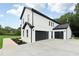 A modern white and black home with a three-car garage, featuring clean lines and contemporary design at 3165 Hall Rd, Dacula, GA 30019