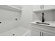 Efficient laundry room with white cabinetry, modern faucet, and functional shelving, perfect for organization at 3165 Hall Rd, Dacula, GA 30019