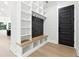 Functional mudroom with built-in storage, a bench, and a stylish door to the exterior at 3165 Hall Rd, Dacula, GA 30019