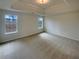 Spacious bedroom with tray ceiling, carpeted floor, and natural light streaming through windows at 40 Zebulon Pl, Covington, GA 30016