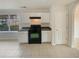 Compact kitchen featuring white cabinets, black appliances, and tile floors at 40 Zebulon Pl, Covington, GA 30016