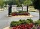 Inviting community entrance featuring stone signage and vibrant landscaping with seasonal flowers at 163 Lorraine Pkwy, Woodstock, GA 30188