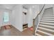 Welcoming entryway with hardwood floors, staircase, and convenient storage bench at 163 Lorraine Pkwy, Woodstock, GA 30188
