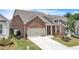 Aerial view of a well-kept brick home featuring a two-car garage, landscaped yard, and inviting curb appeal at 163 Lorraine Pkwy, Woodstock, GA 30188