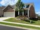 Charming brick home with well-manicured front lawn, landscaped flower beds, and an attached two-car garage at 163 Lorraine Pkwy, Woodstock, GA 30188