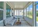 Enclosed sunroom with large windows, stylish rug, and comfortable seating area to enjoy the outdoors indoors at 163 Lorraine Pkwy, Woodstock, GA 30188
