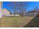 Large, grassy backyard featuring a wood fence, shed, and mature trees offering shade at 4047 Round Stone Trl, Snellville, GA 30039