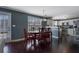A view of a dining area with wood floors, table, and chairs next to a kitchen with white appliances at 4047 Round Stone Trl, Snellville, GA 30039