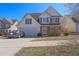 Charming two-story home features a two-car garage, white siding, blue shutters, and manicured landscaping at 4047 Round Stone Trl, Snellville, GA 30039