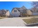 Charming two-story home features a two-car garage, white siding, blue shutters, and manicured landscaping at 4047 Round Stone Trl, Snellville, GA 30039
