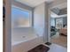 Bright bathroom with a large soaking tub, window, and doorway to the bedroom at 4047 Round Stone Trl, Snellville, GA 30039