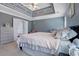 Main bedroom featuring neutral carpet, a large bed, and a decorative trey ceiling at 4047 Round Stone Trl, Snellville, GA 30039