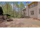 View of the backyard with a stone patio, built-in firepit, and wooded views at 4330 Old Oak Trce, Cumming, GA 30041