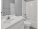 A bright bathroom featuring a white sink, toilet, and bathtub with tiled walls at 4330 Old Oak Trce, Cumming, GA 30041