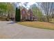 Traditional two-story brick home with a manicured lawn, front porch, and long driveway at 4330 Old Oak Trce, Cumming, GA 30041